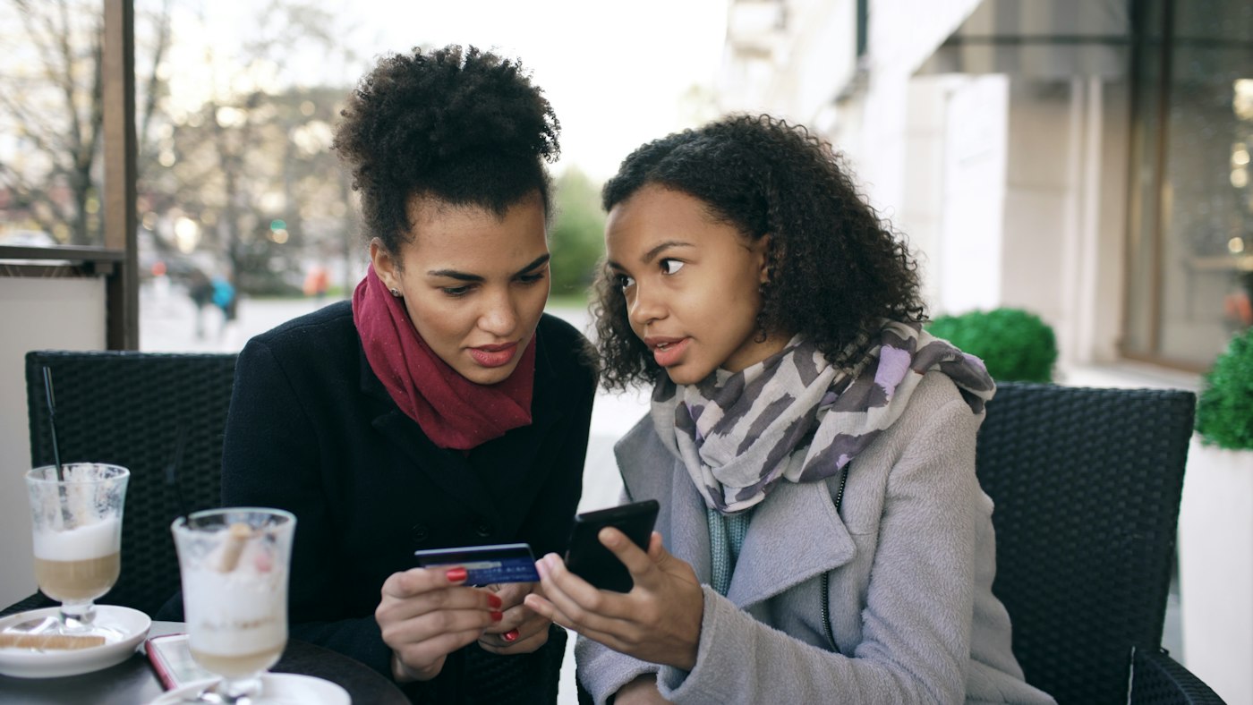 Two women looking at a smartphone together.